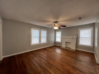 2318 18th Street Lubbock, TX 79401 - Photo 5 of 21 a view of an empty room with wooden floor fireplace and a window