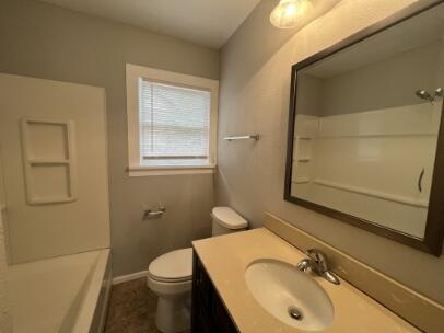 2318 18th Street Lubbock, TX 79401 - Photo 10 of 21 a bathroom with a sink toilet and mirror