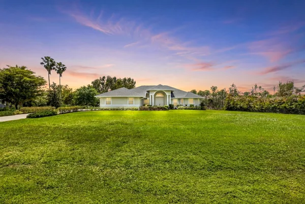 a house view with swimming pool in front of it