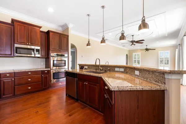 a kitchen with stainless steel appliances granite countertop a refrigerator stove and sink