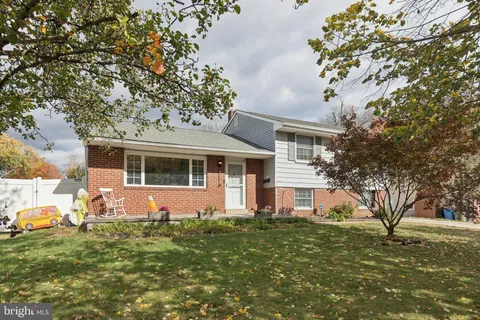 a front view of house with yard and trees around