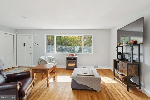 a dining room with furniture a chandelier and wooden floor
