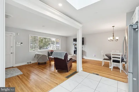 a view of a hallway with wooden floor and a bathroom