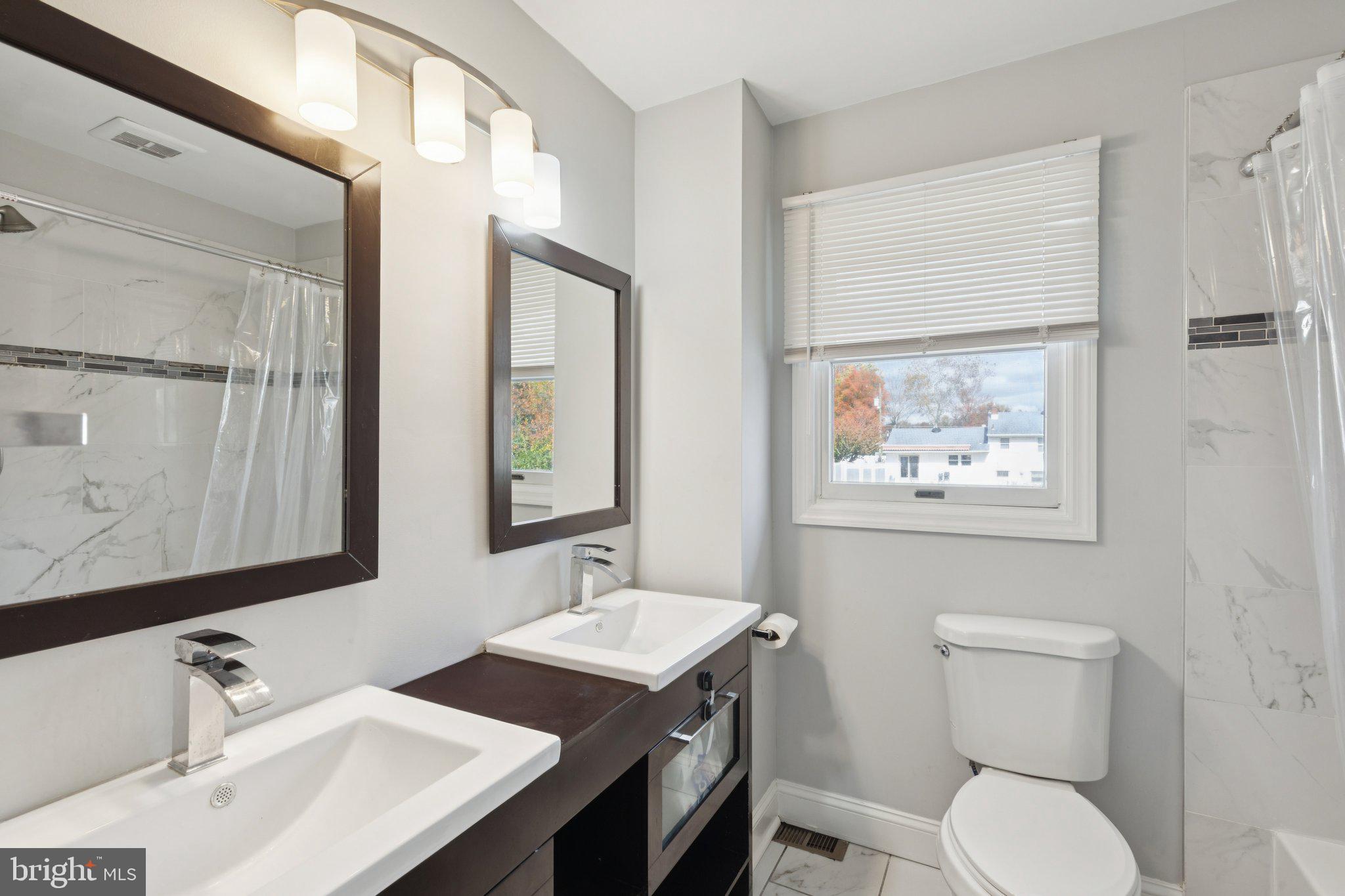 407 Yorkshire Road Cherry Hill, NJ 08034 - Photo 27 of 62 a bathroom with a toilet a sink and mirror