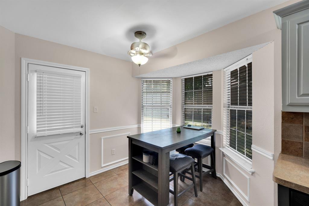 1001 Short Line Boulevard Midlothian, TX 76065 - Photo 17 of 26 Breakfast nook featuring bay windows with blinds, wainscoting, and tile flooring