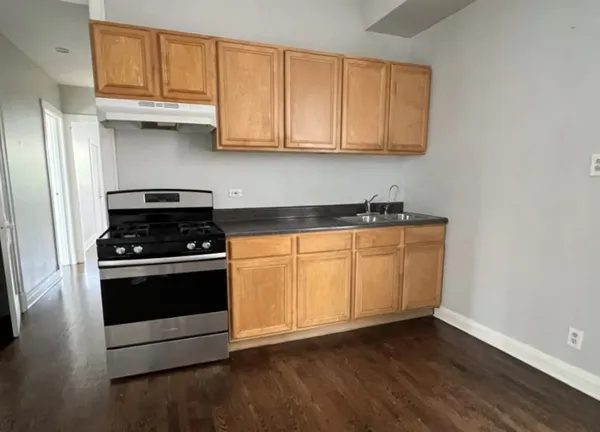 a kitchen with granite countertop white cabinets and stainless steel appliances