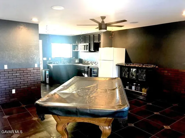 a room with stainless steel appliances kitchen island granite countertop a sink and cabinets