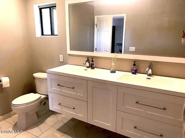 a bathroom with a toilet a sink and mirror