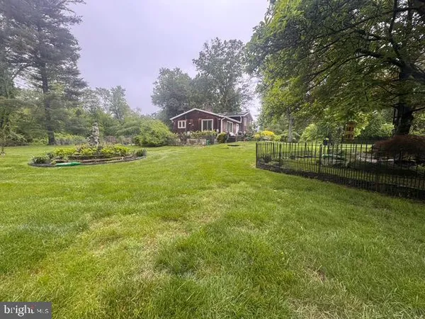 a front view of a house with a garden and trees
