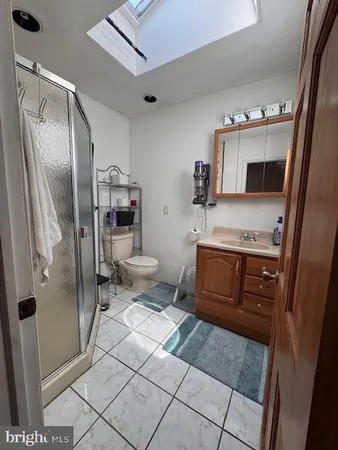 a bathroom with a granite countertop sink mirror vanity and toilet