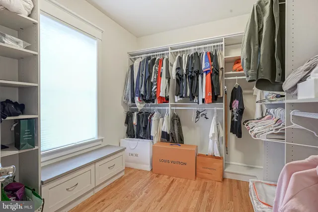 a view of walk in closet with clothes and shoes