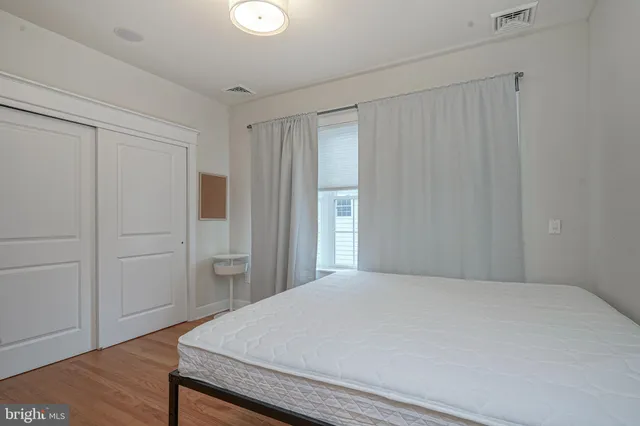 a bedroom with a bed and wooden floor