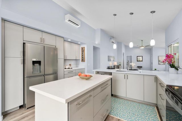 a kitchen that has a lot of cabinets in it and wooden floors
