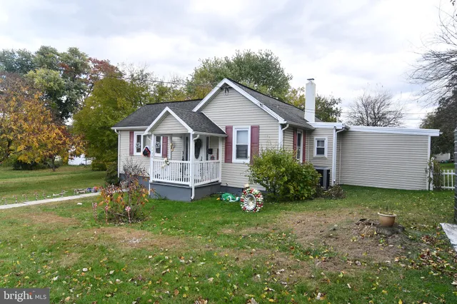 a view of a house with a big yard and large trees