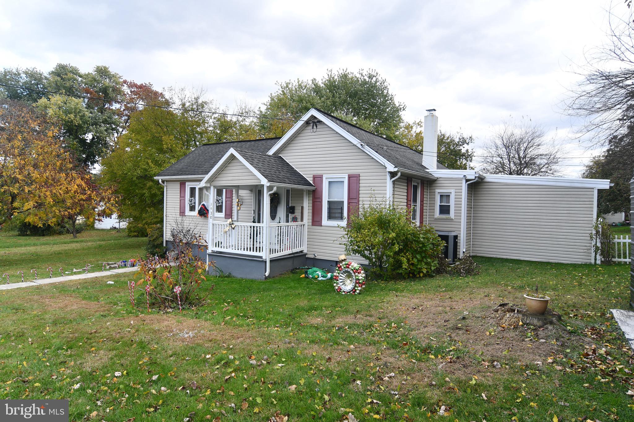 a view of a house with a big yard and large trees