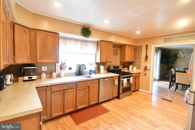 a large kitchen with kitchen island granite countertop a sink and cabinets