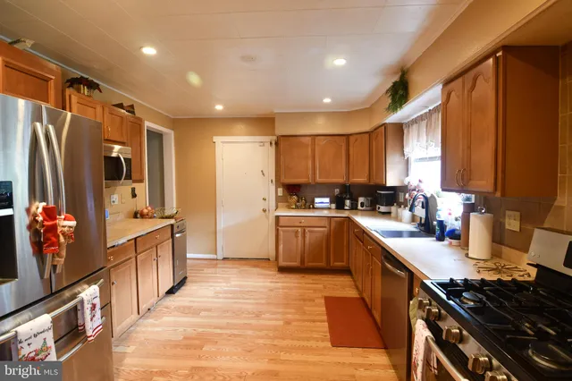 a kitchen with stainless steel appliances sink stove refrigerator and cabinets