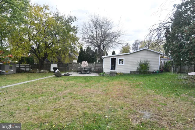 a view of a house with backyard and tree