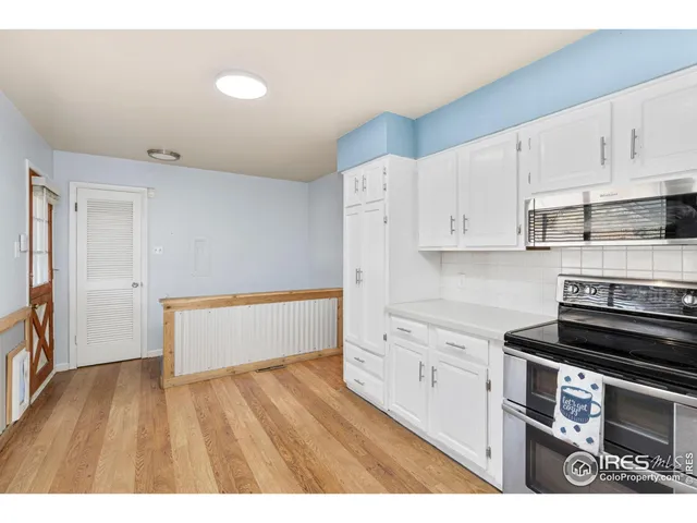 a kitchen with wooden floors and appliances