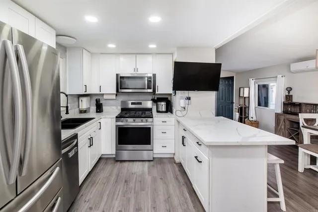 a kitchen with stainless steel appliances a stove refrigerator sink and microwave