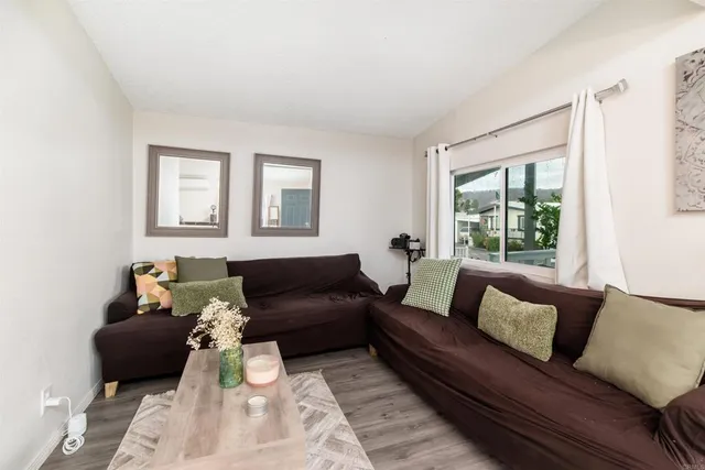 a living room with furniture a wooden floor and a window