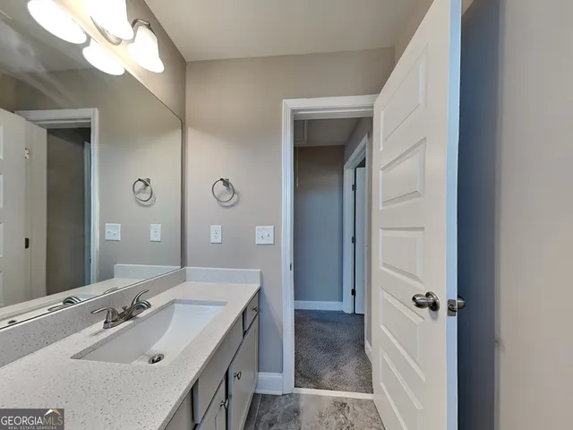 a bathroom with a sink and mirror with shower