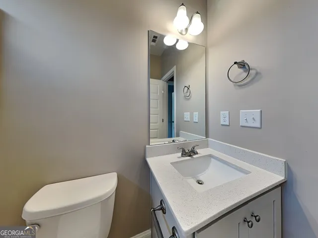 a bathroom with a toilet sink and mirror