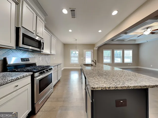 a kitchen with stainless steel appliances granite countertop a stove and a sink