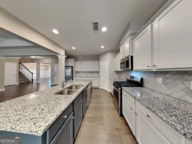 a kitchen with stainless steel appliances granite countertop a stove top oven a sink and dishwasher