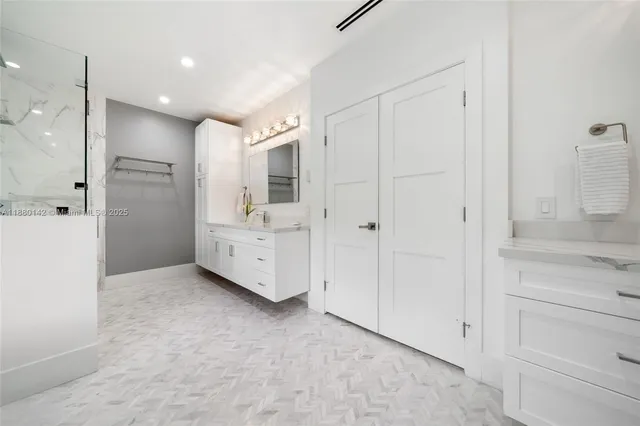 a view of a bathroom with closet and mirror