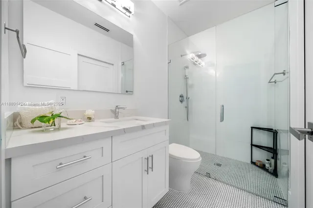 a spacious bathroom with a granite countertop sink a toilet and a mirror