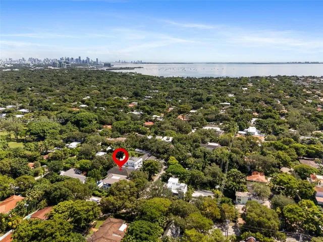 an aerial view of residential houses with outdoor space and trees
