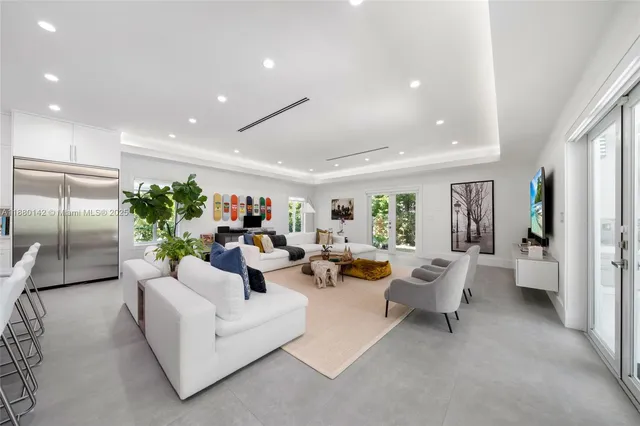 a living room with fireplace furniture and a view of kitchen
