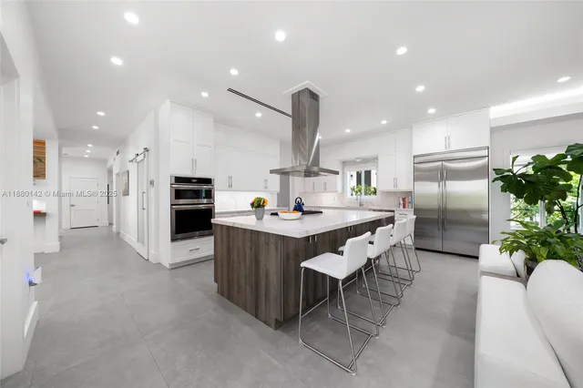 a kitchen with stainless steel appliances kitchen island granite countertop a table and chairs in it