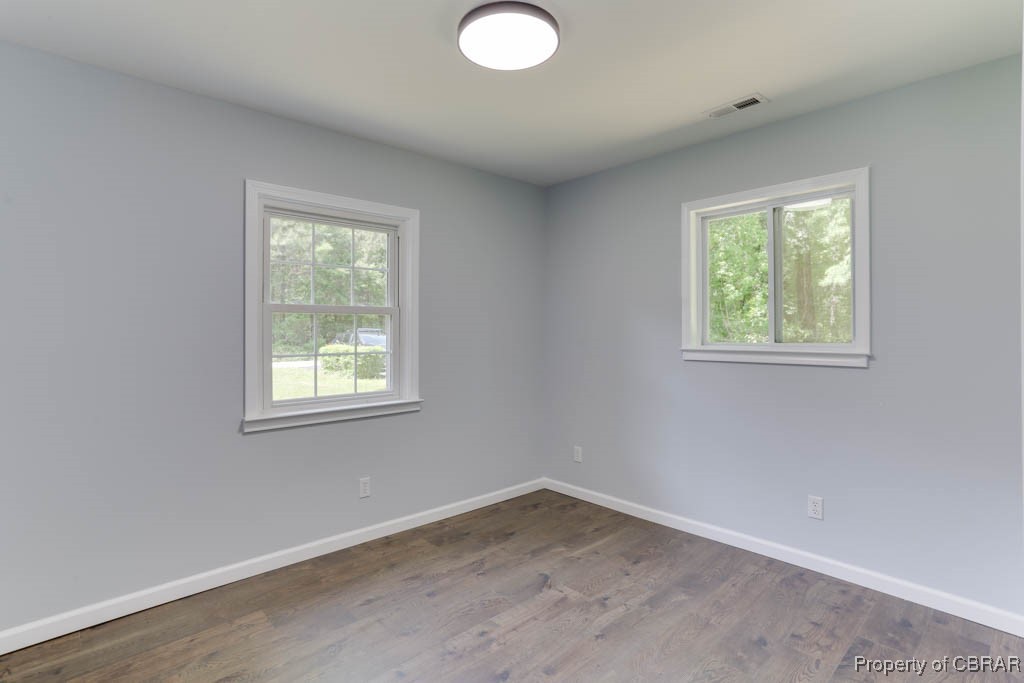 917 Chapel Neck Road North, VA 23128 - Photo 14 of 29 Spare room featuring plenty of natural light, baseboards, and wood finished floors