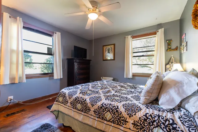 a bedroom with a bed and wooden floor