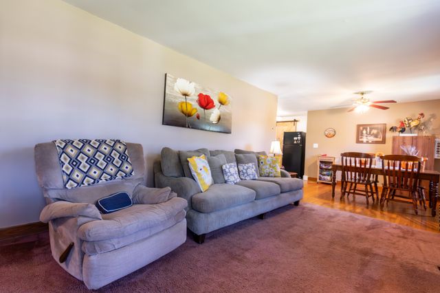 a living room with furniture and a dining table with bookshelf