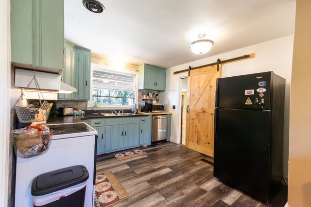 a kitchen with a refrigerator and a stove top oven