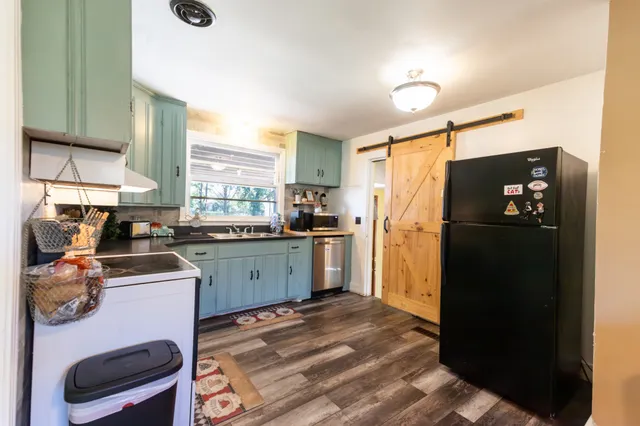 a kitchen with a refrigerator and a stove top oven