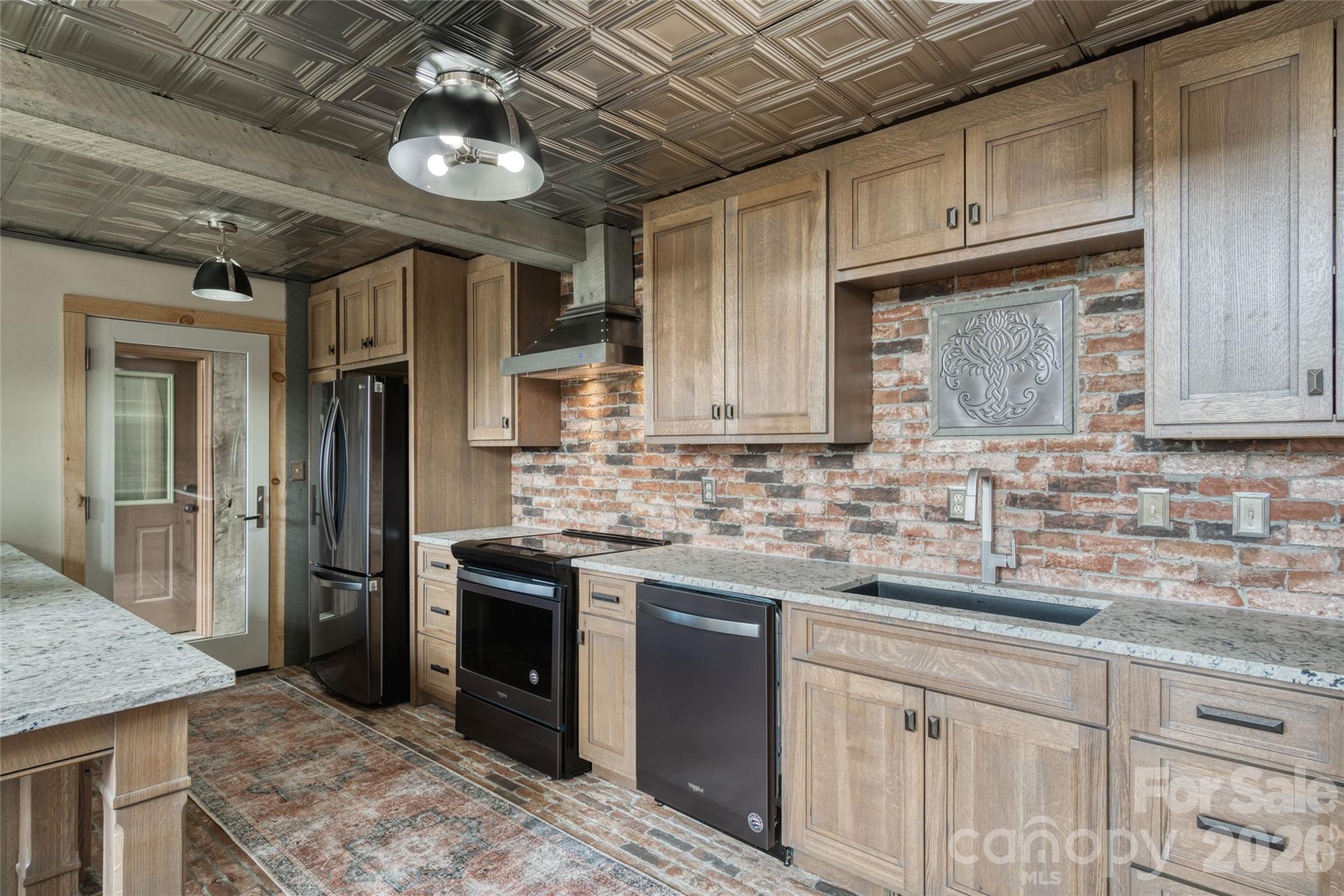 461 Ferguson Cove Loop Clyde, NC 28721 - Photo 16 of 46 a kitchen with stainless steel appliances granite countertop a sink stove and refrigerator