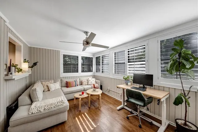 a living room with furniture floor to ceiling window and wooden floor