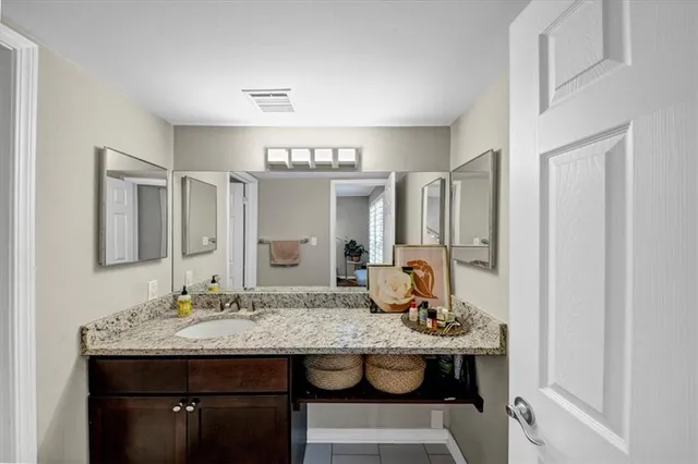a bathroom with a granite countertop sink a toilet and a mirror