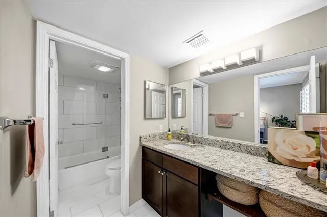 a bathroom with a granite countertop sink mirror and shower