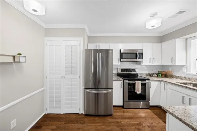 a kitchen with a stove refrigerator and microwave