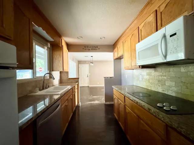a kitchen with stainless steel appliances granite countertop a sink stove and cabinets