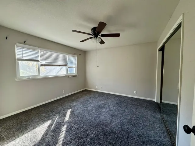 a view of a livingroom with a ceiling fan and window