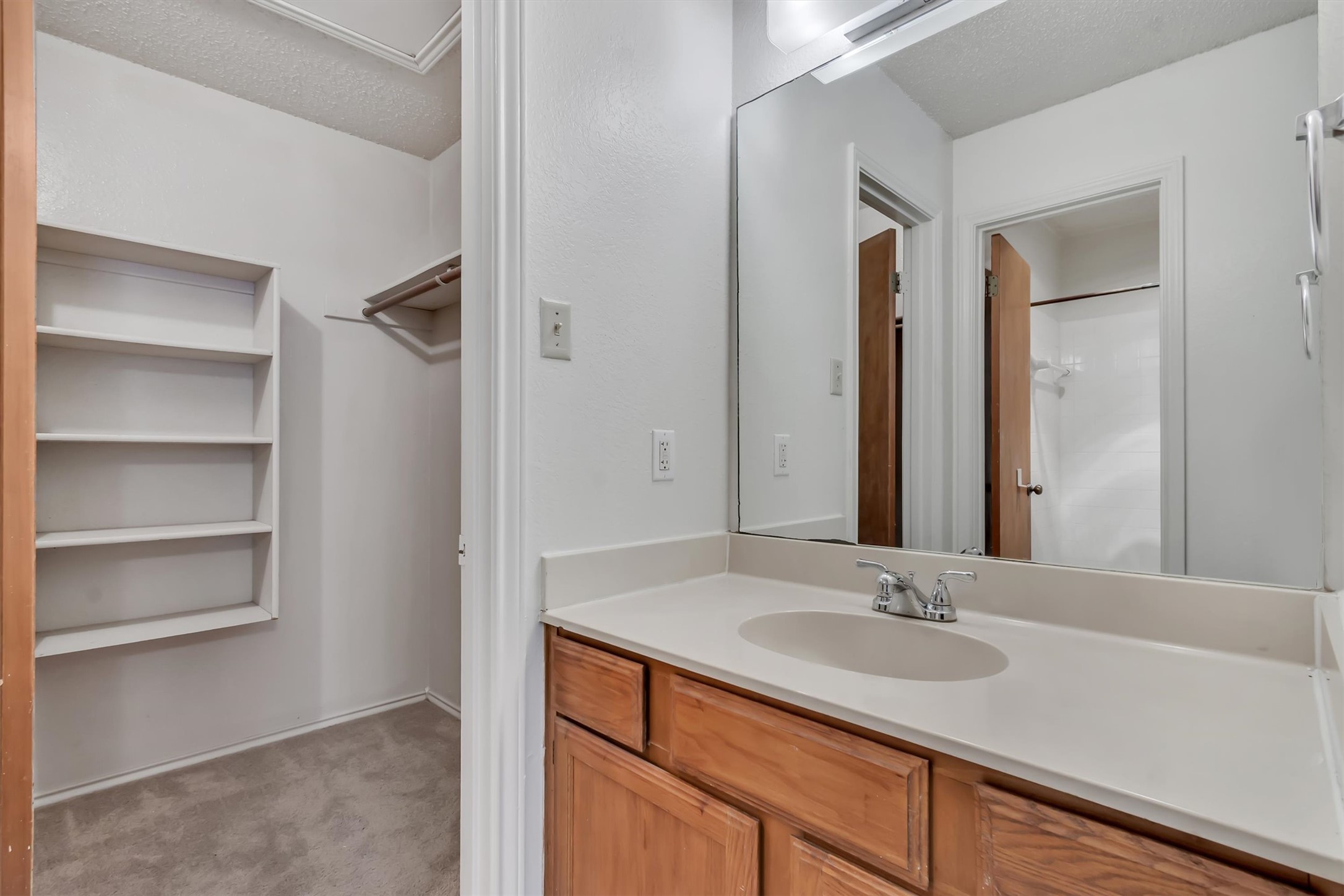 7802 Topawa Cove, Unit B Austin, TX 78729 - Photo 21 of 32 Functional vanity and mirror create a welcoming atmosphere in this combined bath and closet area.