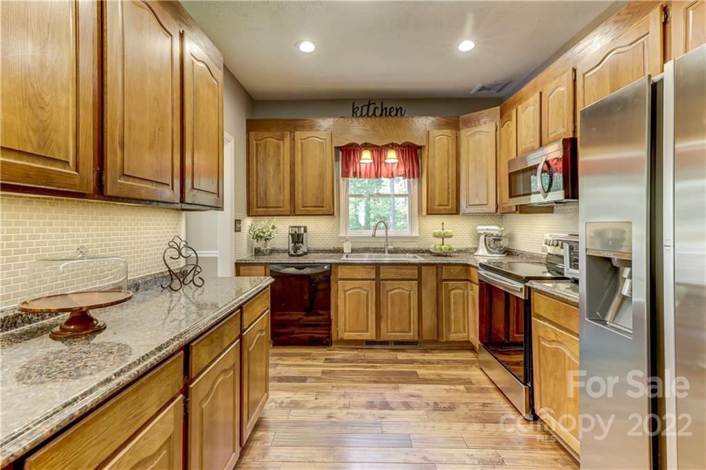 339 East Rebound Road Lancaster, SC 29720 - Photo 19 of 40 a kitchen with stainless steel appliances granite countertop wooden cabinets a stove top oven a sink and dishwasher