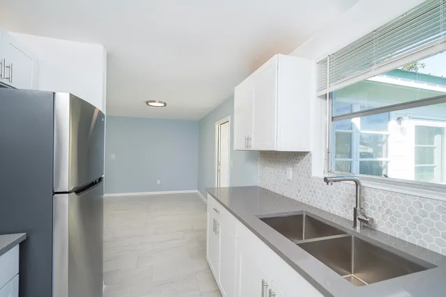 a kitchen with a refrigerator sink and cabinets