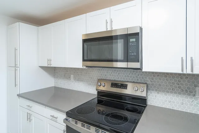 a stove top oven sitting inside of a kitchen